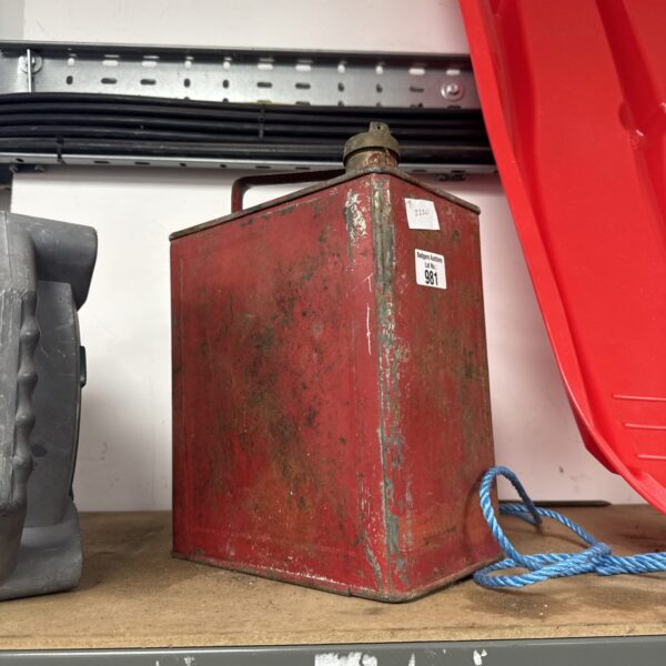 Red vintage Valor fuel can with signs of wear.