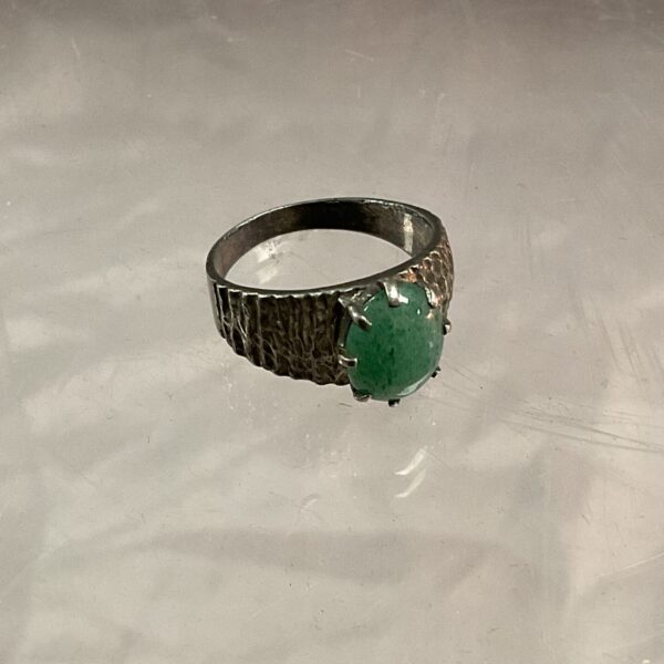 Close-up of a silver ring with a jade stone.