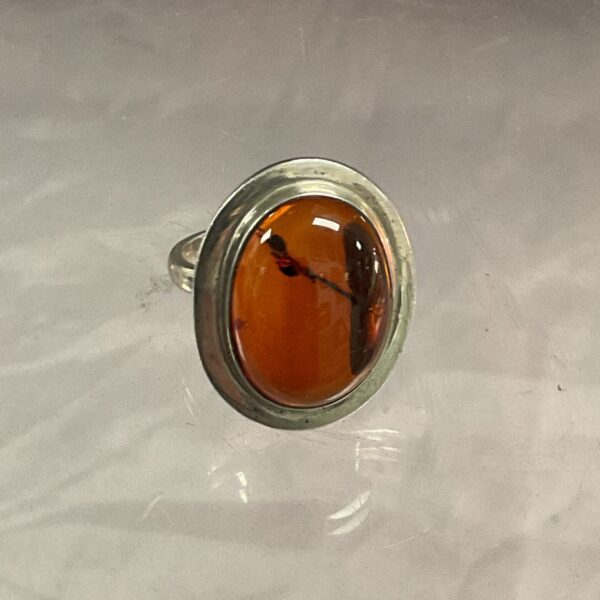 Close-up of a vintage silver ring with a honey amber stone.