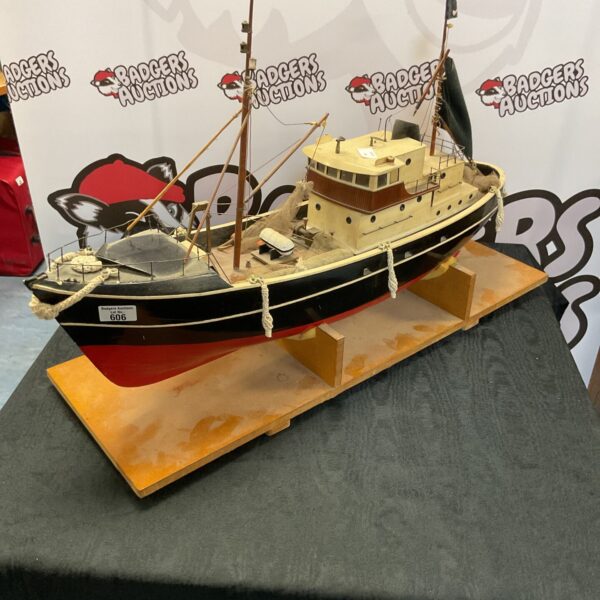 Detailed side view of the RC model ship on a wooden stand.