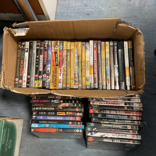 A cardboard box filled with a lot of horror DVDs.