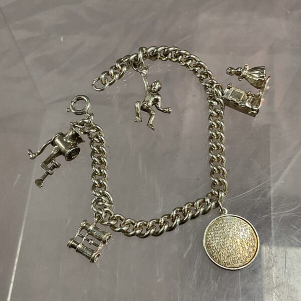 Vintage silver charm bracelet with five unique novelty charms.
