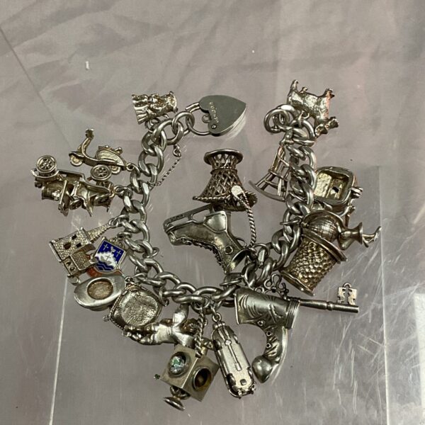 Vintage silver charm bracelet with 21 charms, a collectible jewellery piece.