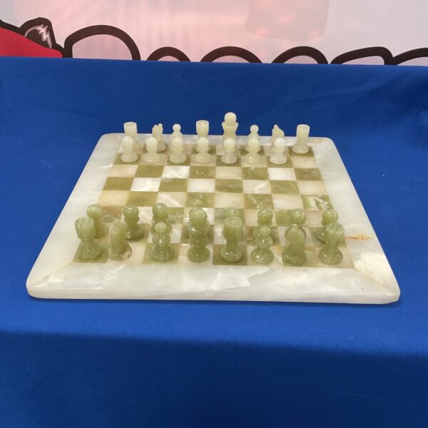 Vintage marble chess set with carved pieces on a stone board.