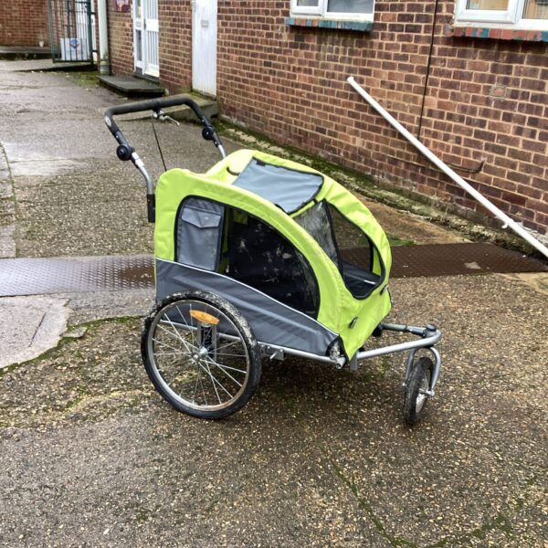 Side view of a grey and yellow pet bike trailer.