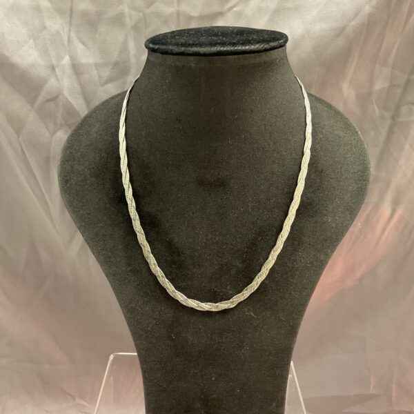 Close-up of a 925 silver woven necklace on a display stand.