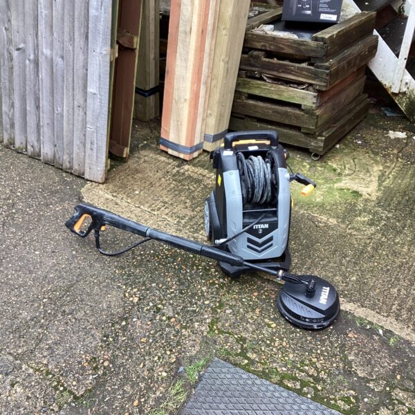 Used Titan power washer in a garden setting for outdoor cleaning.