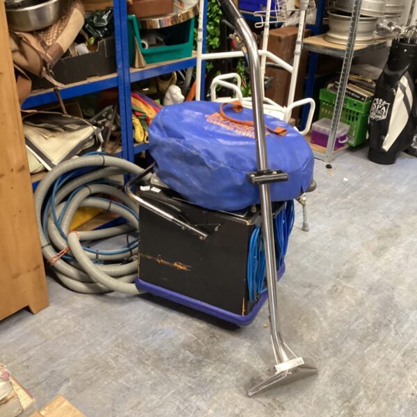 Vintage Extracta carpet cleaning machine with hose attachment.