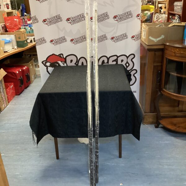 Pair of snooker cues presented on a table.