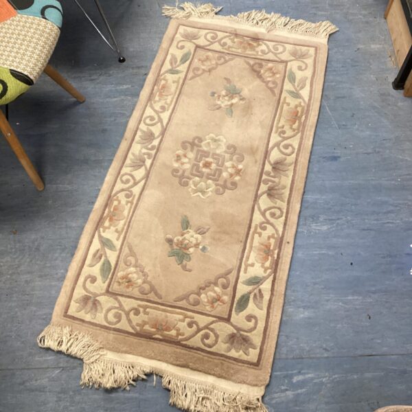 Cream floral runner rug with woven texture.
