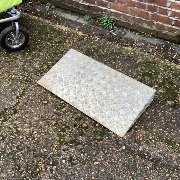 Durable metal checkerplate ramp for loading and access.