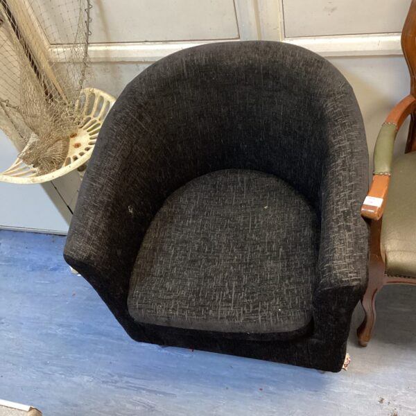 Black tub chair, modern accent seating for a home.