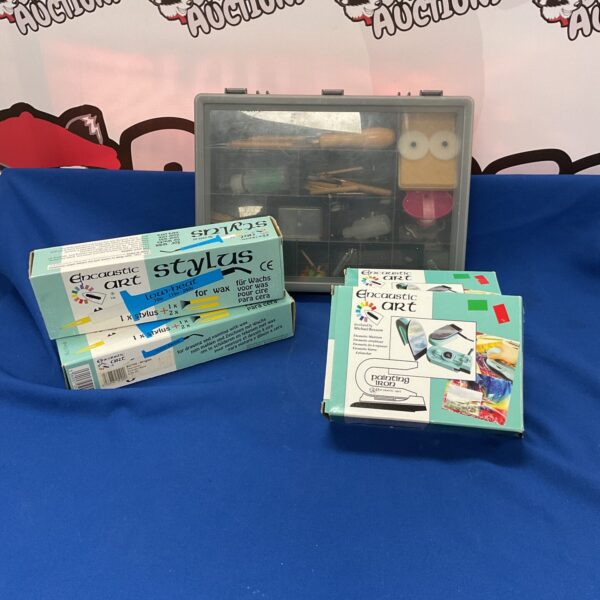 Encaustic art wax pens, painting irons, and art supplies in a box.
