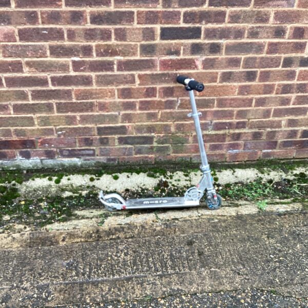Silver Micro scooter with folding handlebars, ready for urban travel.