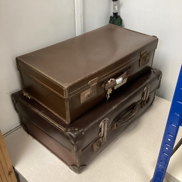 Vintage brown leather suitcases stacked, antique travel luggage.