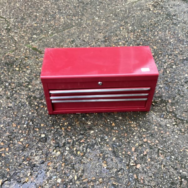 Front view of a vintage red metal tool chest.