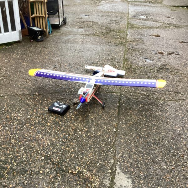 Vintage remote control aeroplane with controller, needing restoration.