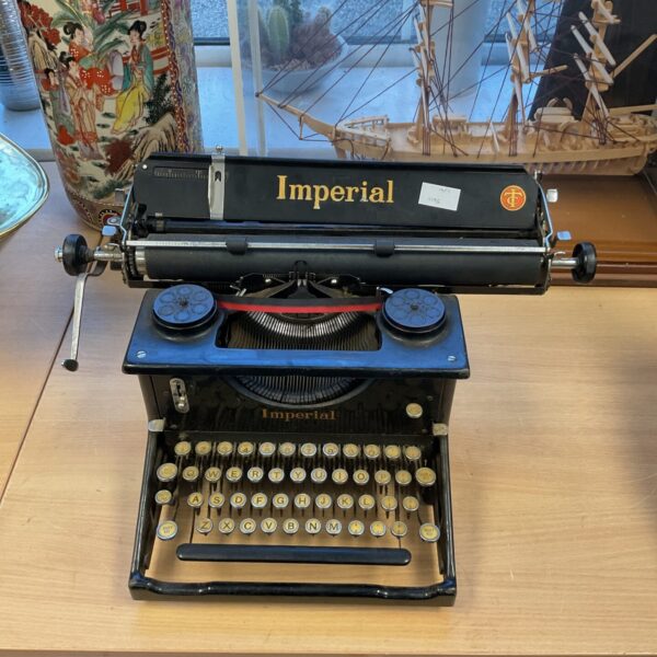 Vintage Imperial mechanical typewriter, black finish, antique office equipment.