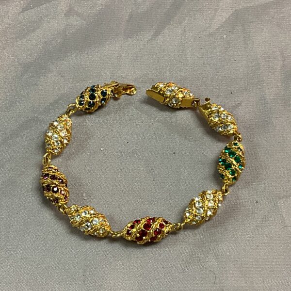 Vintage Jackie Kennedy style egg bracelet with ruby, emerald, and sapphire links.
