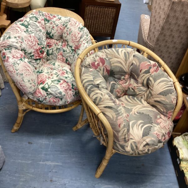 Pair of vintage bamboo conservatory chairs with floral cushions.