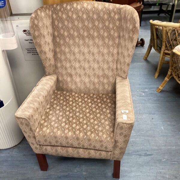 Patterned wingback chair with a textured fabric and classic design.