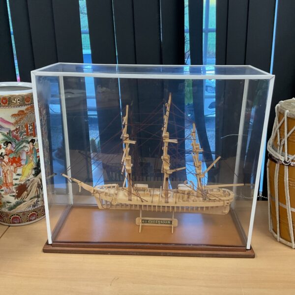 Detailed wooden model of the Cutty Sark ship in a display case.