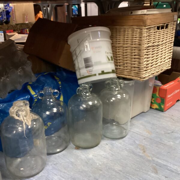 Three clear glass wine demijohns for fermentation and brewing.