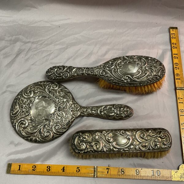 Antique silver dressing table set with mirror and brushes.