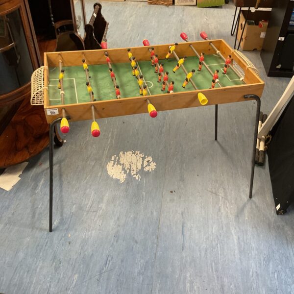 Vintage green football table with classic player figures.