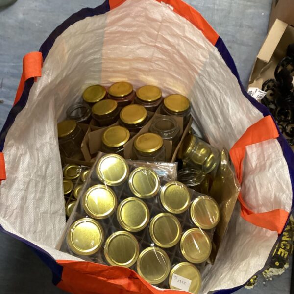Large quantity of vintage glass jam jars with metal lids.