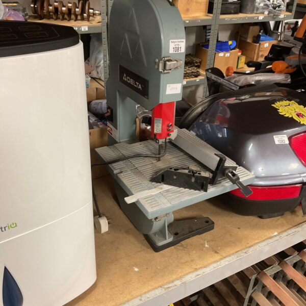 Vintage Delta bench band saw in a workshop setting.