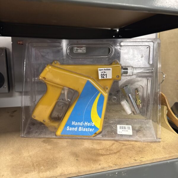 Close-up of handheld sand blaster kit with hopper and handle.