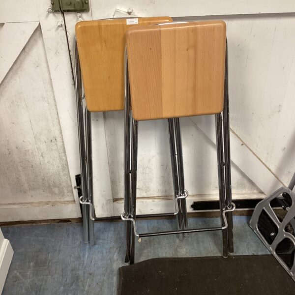 Vintage folding metal stools with wooden seats for kitchen use.