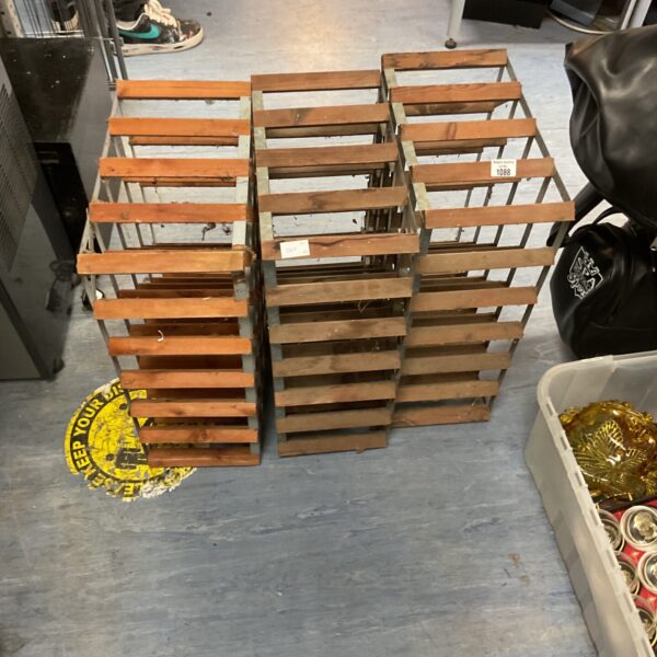 Three vintage wooden wine racks for wine storage.