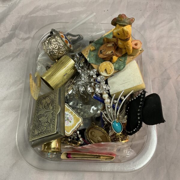 Tray of vintage jewellery and collectibles, including brooches and trinkets.