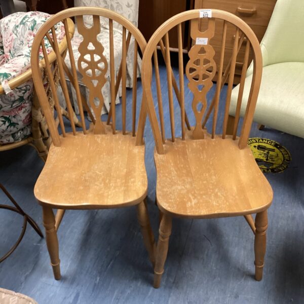 Two vintage wheelback chairs with wooden frames.