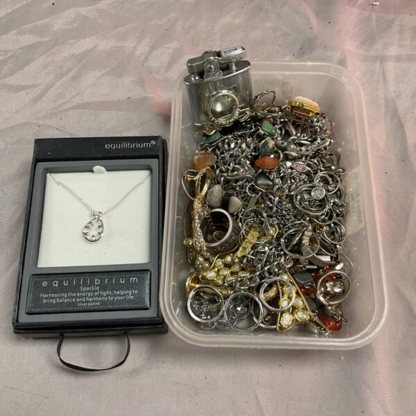 Mixed jewellery lot with vintage Ronson lighter on display.