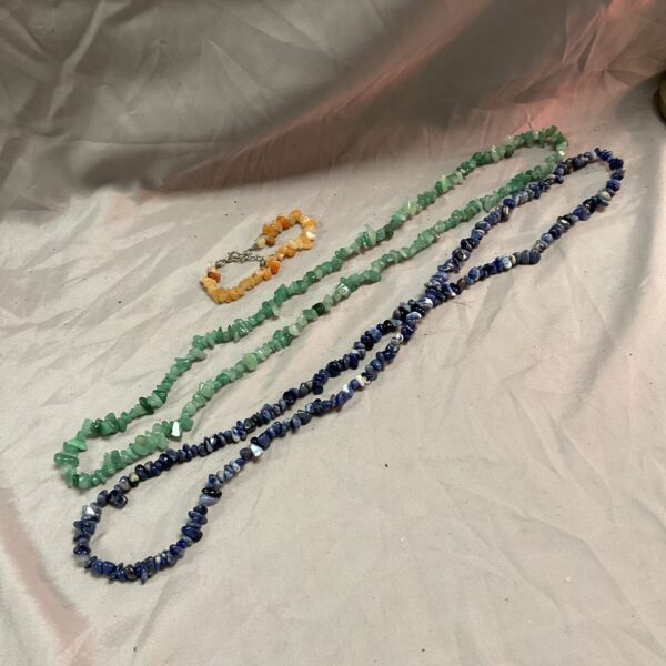 Vibrant colourful stone necklaces and bracelet on a white background.