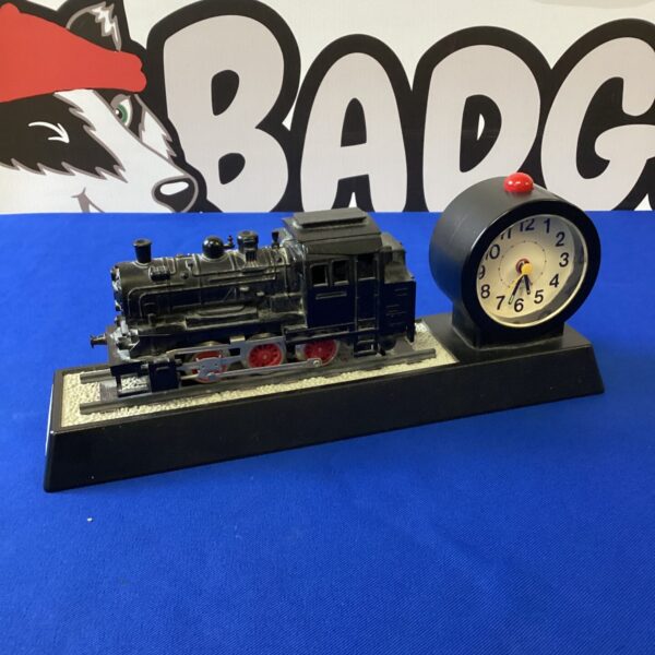 Vintage steam train alarm clock with red and black details.