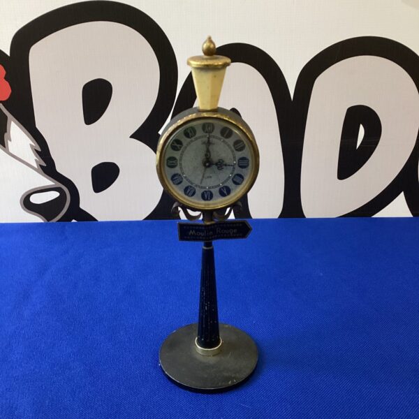 Vintage Rhythm lamp alarm clock on a dark surface.