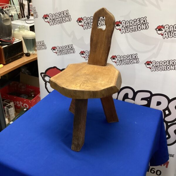 Rustic hand-carved birthing chair with a sculpted wooden seat.