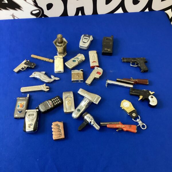 Collection of vintage novelty lighters, including handgun and mobile phone designs.