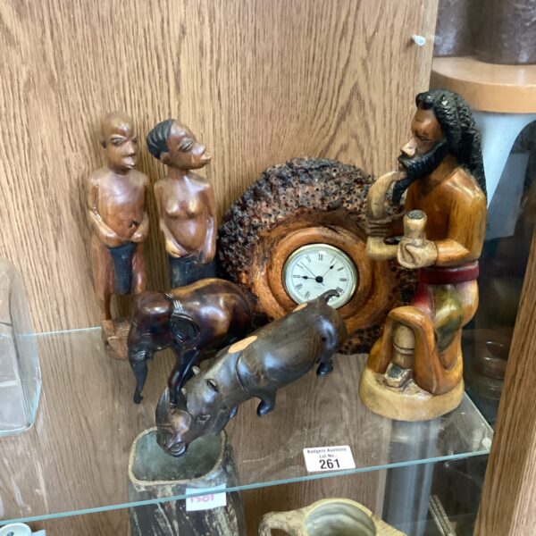 Handcrafted African sculptures with a clock, showcasing tribal art.