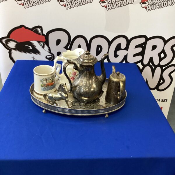 Vintage silverplate tea set with teapot, jug, and porcelain mug.