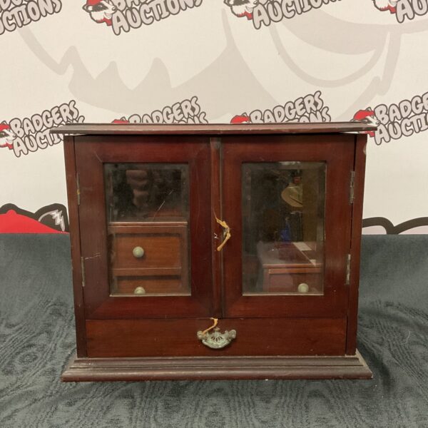 Front view of a vintage mahogany apothecary cabinet with glass doors.
