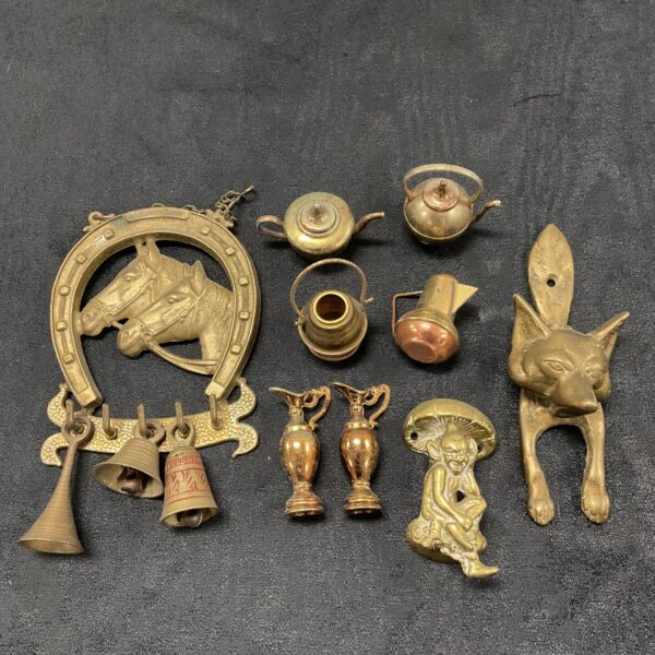 Vintage brassware collection featuring a fox door knocker and decorative vessels.