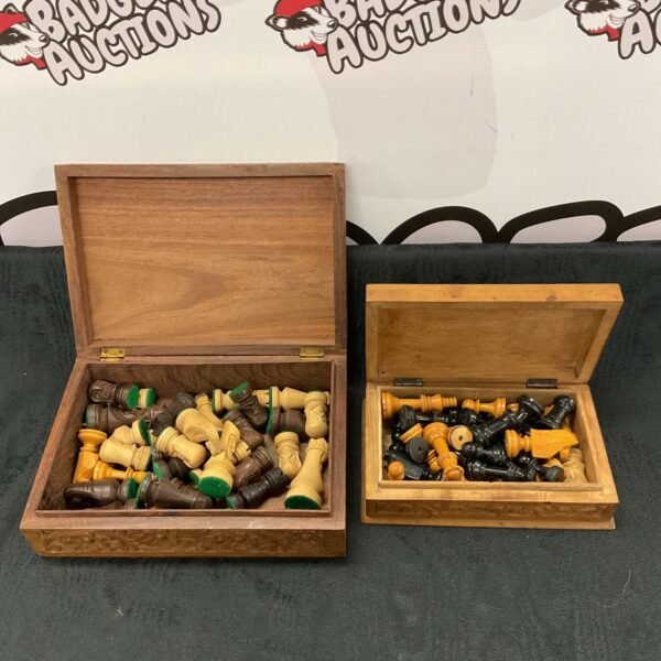 Open carved wooden chess box with pieces inside.