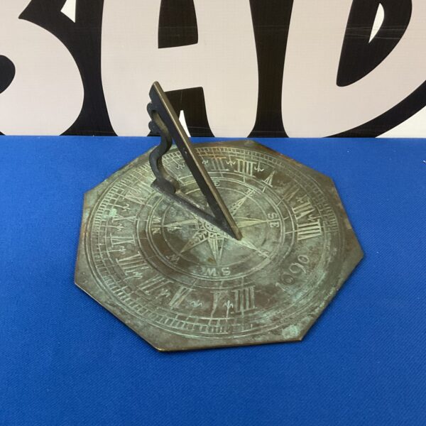 Antique bronze sundial with detailed hour markings and patina.