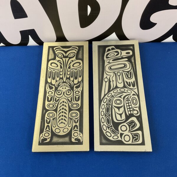 Vintage West Coast Indian plaques with intricate animal carvings.