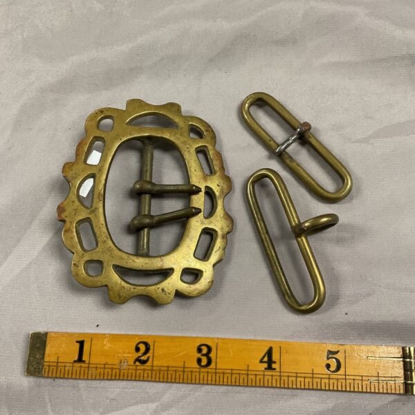 Antique brass belt buckles with intricate floral and geometric designs.